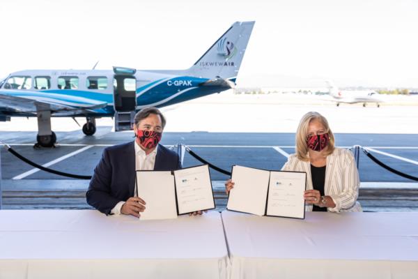 ITAC CEO Keith Henry and YVR's CEO Tamara Vrooman hold up their signed agreements.