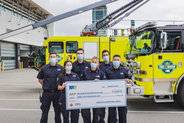 Des pompiers posent avec un gros chèque