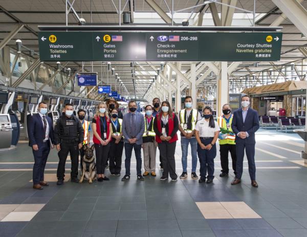 Photo de groupe de travailleurs de l’aéroport avec le ministre des Transports du Canada Omar Alghabra