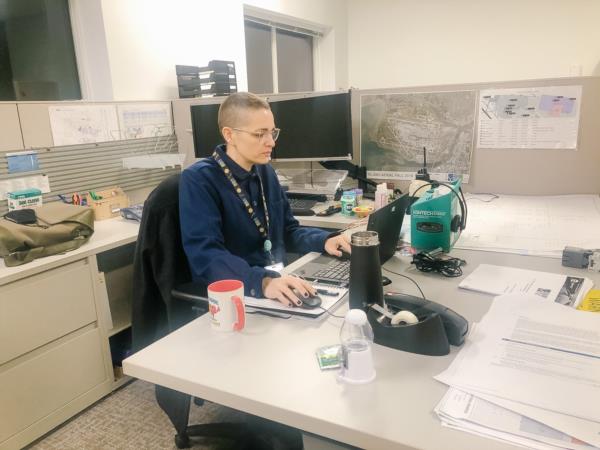 Robyn sits at her desk in front of her laptop. 
