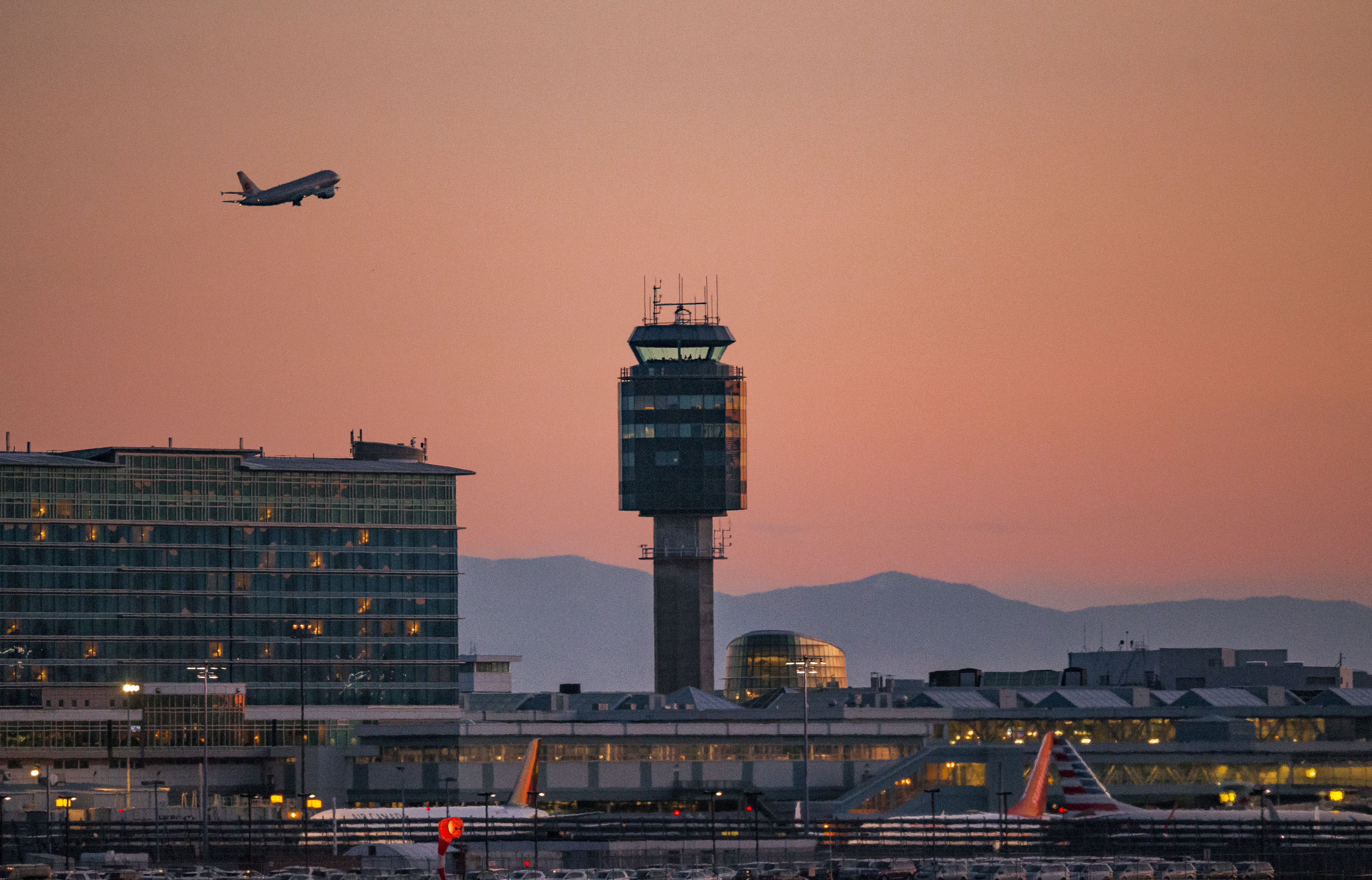Photo of YVR at sunset with a plane departing.