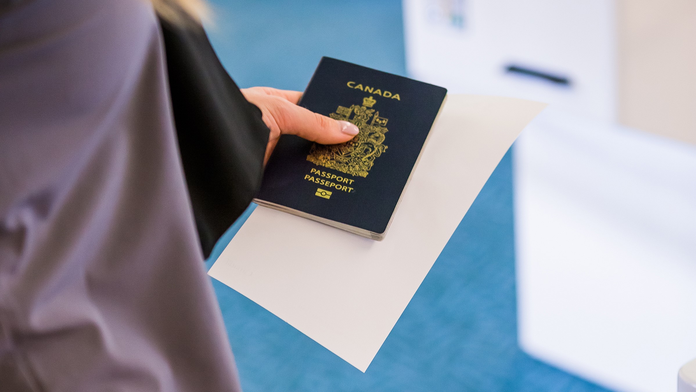Person holding onto a Canadian passport.