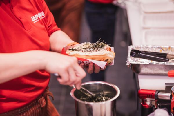 Japadog employee preparing hot dog 