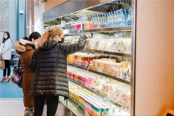 Passengers selecting beverages from refrigerator 
