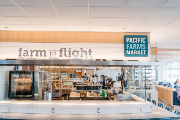 Pacific Farms Market sign in the storefront with a "farm to flight" sign