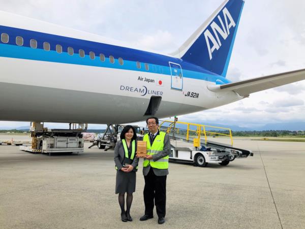All Nippon Airways – Deux employés d’All Nippon Airways se tiennent devant le Dreamliner de la compagnie arienne pour recevoir leur prix.