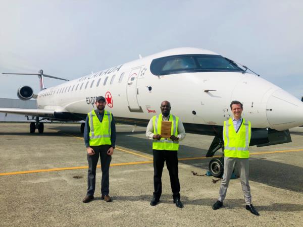 Jazz Aviation – Trois employés de Jazz Aviation se tiennent devant leur avion pour une photo de leur prix.