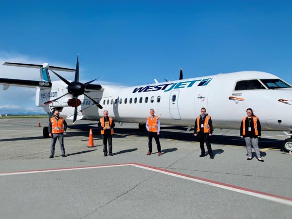 WestJet Encore – Des membres de l’équipe WestJet présentent leur prix tout en maintenant une distance sécuritaire. 