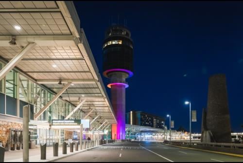 YVR Control Tower lit up in orange pink and purple
